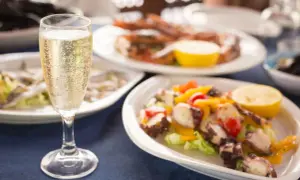 Calice di champagne con stuzzichini per aperitivo: polpo, gamberi e alici.