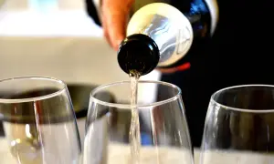 Versando vino bianco nei calici, un'anteprima dei sapori dei colli piacentini.