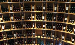 Scaffali pieni di bottiglie di vino, tra cui un ottimo vino di Bordeaux, in una cantina.