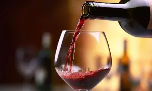 Versando vino rosso in un calice, un assaggio dei migliori Barolo.
