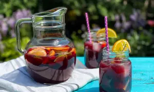Rinfrescante sangria all'italiana in caraffa e bicchieri, con fette d'arancia e lime, pronta per un picnic estivo.