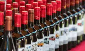 Bottiglie di bergerac vino con etichette raffiguranti furgoni e auto d'epoca.