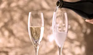 Versando vino in un bicchiere, creando bollicine che ricordano il vino frizzante.