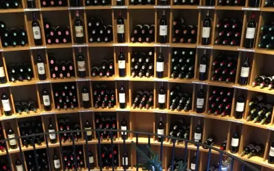 Scaffali pieni di bottiglie di vino, tra cui un ottimo vino di Bordeaux, in una cantina.