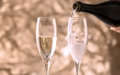 Versando vino in un bicchiere, creando bollicine che ricordano il vino frizzante.