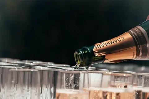 Champagne versato in bicchieri, un brindisi che celebra il millesimato significato.
