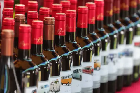 Bottiglie di bergerac vino con etichette raffiguranti furgoni e auto d'epoca.