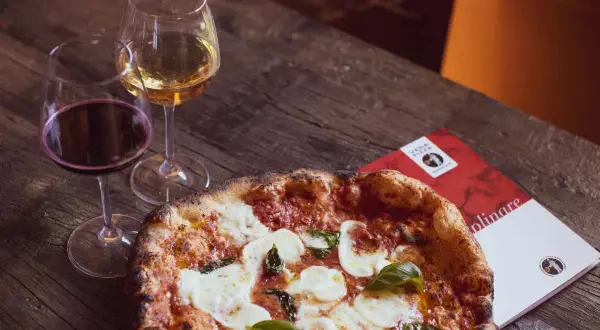 Una pizza margherita con vino bianco o rosso, un abbinamento perfetto per una serata gustosa.