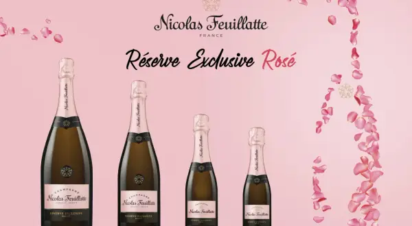 Bottiglie di Nicolas Feuillatte Réserve Exclusive Rosé, tra i nomi champagne famosi, su sfondo rosa con petali.