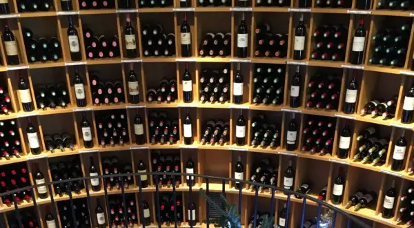 Scaffali pieni di bottiglie di vino, tra cui un ottimo vino di Bordeaux, in una cantina.