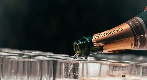 Champagne versato in bicchieri, un brindisi che celebra il millesimato significato.