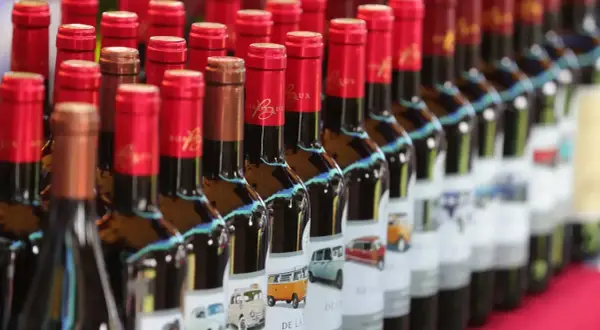 Bottiglie di bergerac vino con etichette raffiguranti furgoni e auto d'epoca.