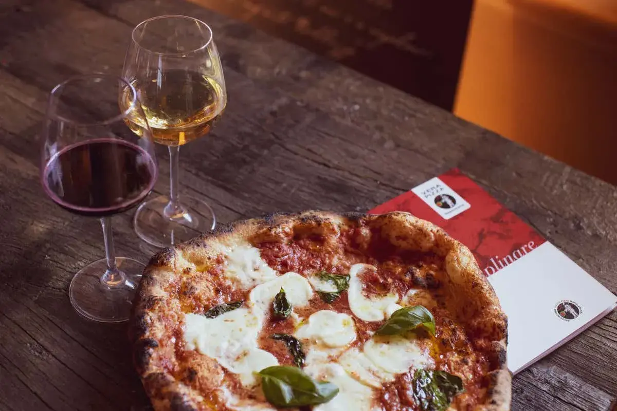 Una pizza margherita con vino bianco o rosso, un abbinamento perfetto per una serata gustosa.