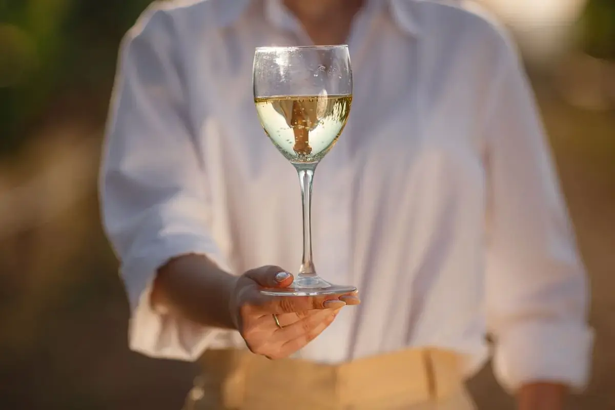 Calice di vino bianco altoatesino, riflessi dorati e bollicine danzanti. Un sorso di sole.