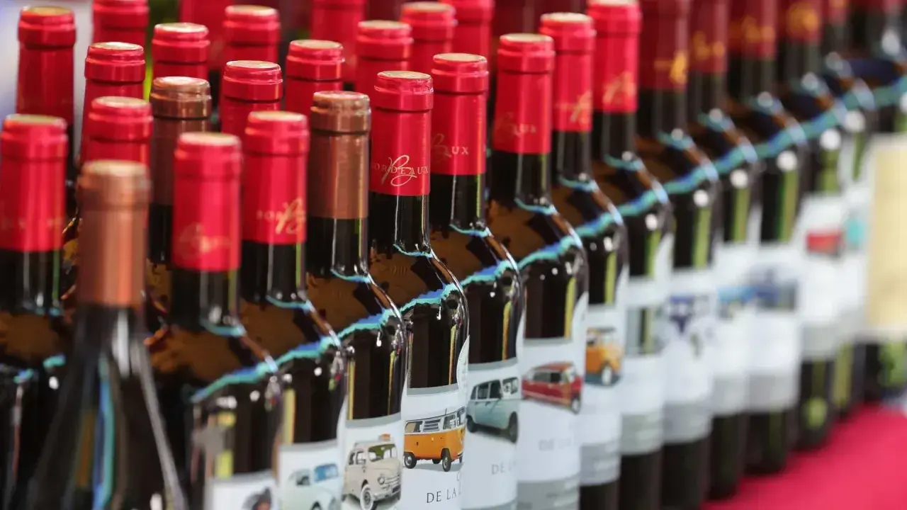 Bottiglie di bergerac vino con etichette raffiguranti furgoni e auto d'epoca.
