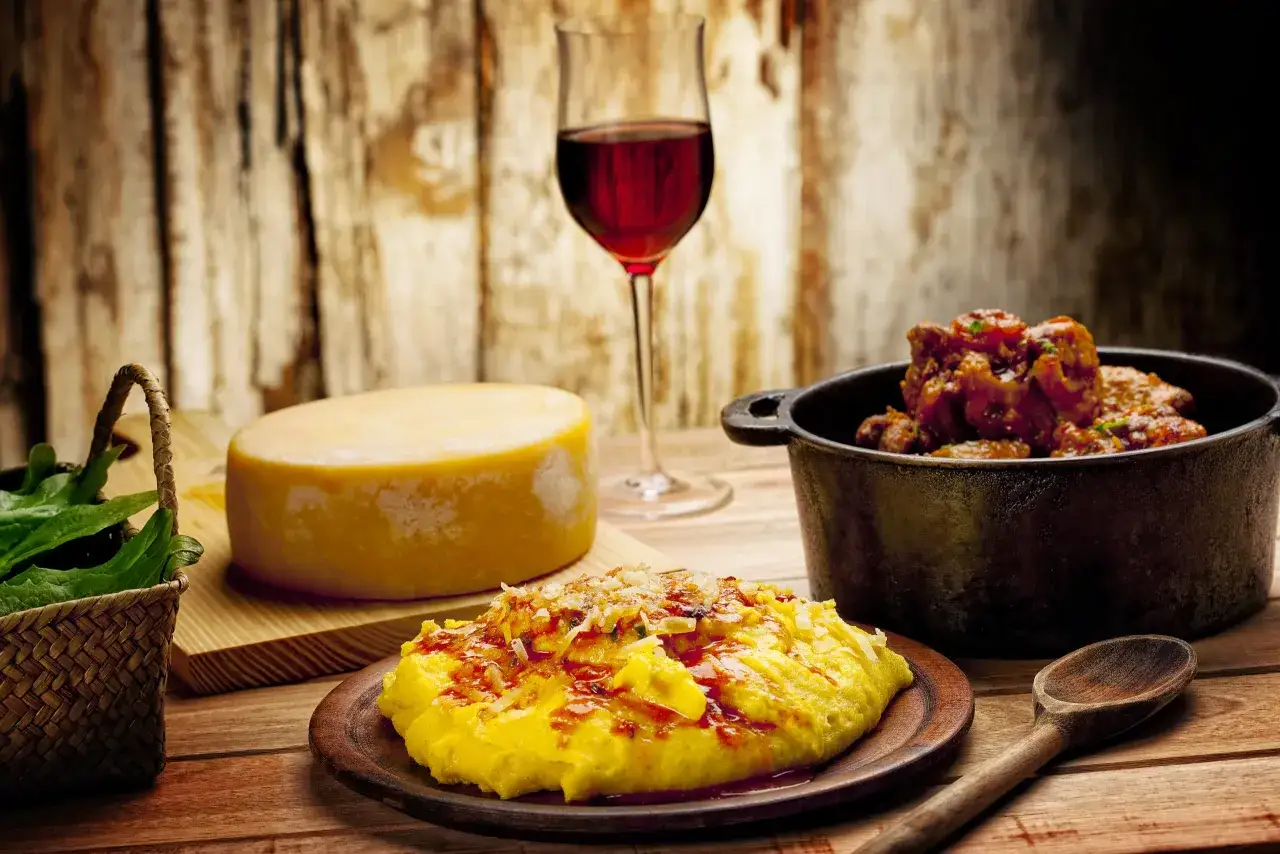 Un bicchiere di vino rosso, perfetto vino da abbinare alla polenta, formaggio e un gustoso spezzatino.
