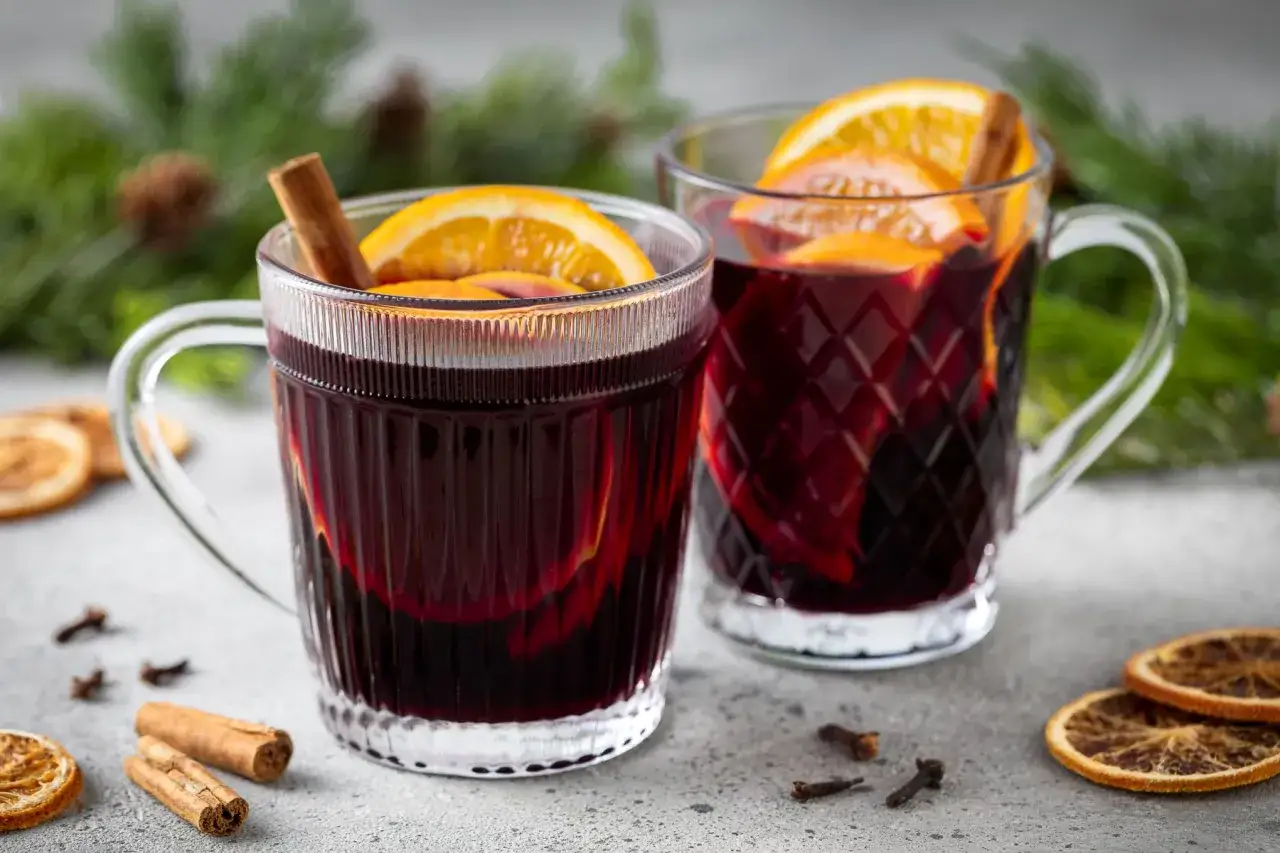 Due tazze di vino per vin brul&eacute;, con arancia e cannella, pronte per scaldare le serate invernali.