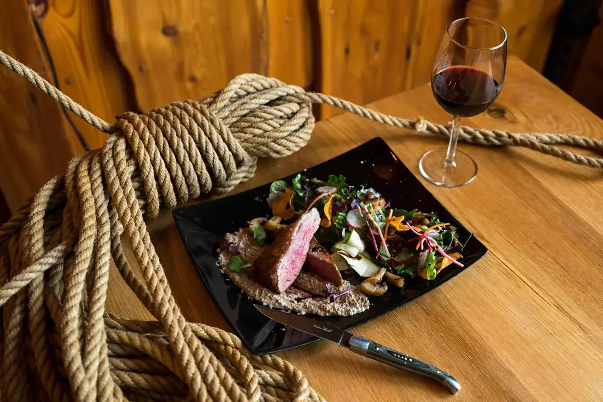 Un succulento filetto di manzo con insalata fresca, un bicchiere di vino rosso e una corda rustica. Perfetti cabernet sauvignon abbinamenti per una cena indimenticabile.