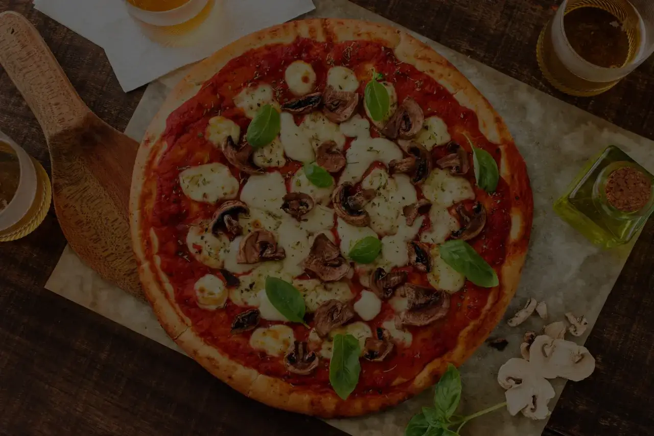 Pizza ai funghi e mozzarella, con un bicchiere di vino e focaccia.