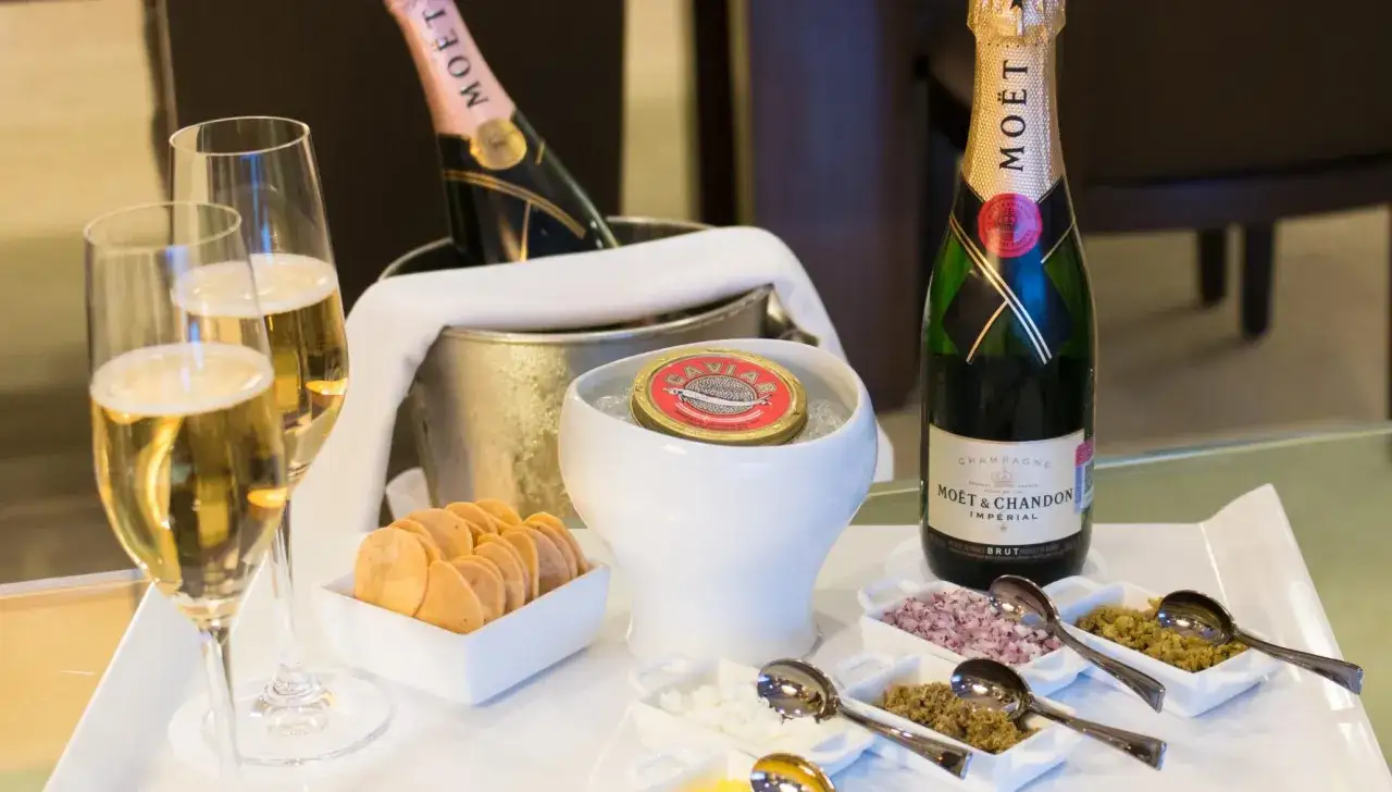 Stuzzichini per aperitivo con champagne Mo&euml;t & Chandon: caviale, crostini, cipolla rossa tritata e altri condimenti.