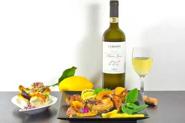 Un delizioso coniglio arrosto con limone e erbe aromatiche, perfetto per un abbinamento vino coniglio con Albana Secco.