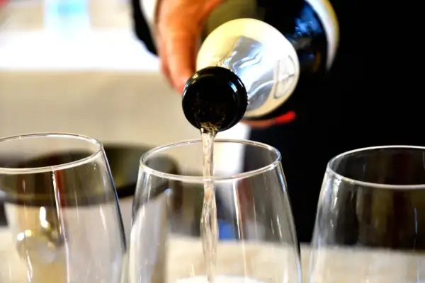 Versando vino bianco nei calici, un'anteprima dei sapori dei colli piacentini.
