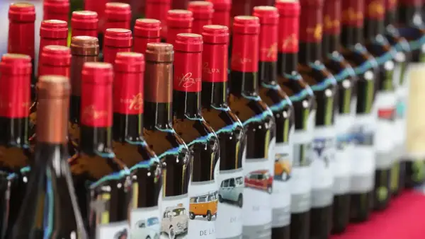 Bottiglie di bergerac vino con etichette raffiguranti furgoni e auto d'epoca.